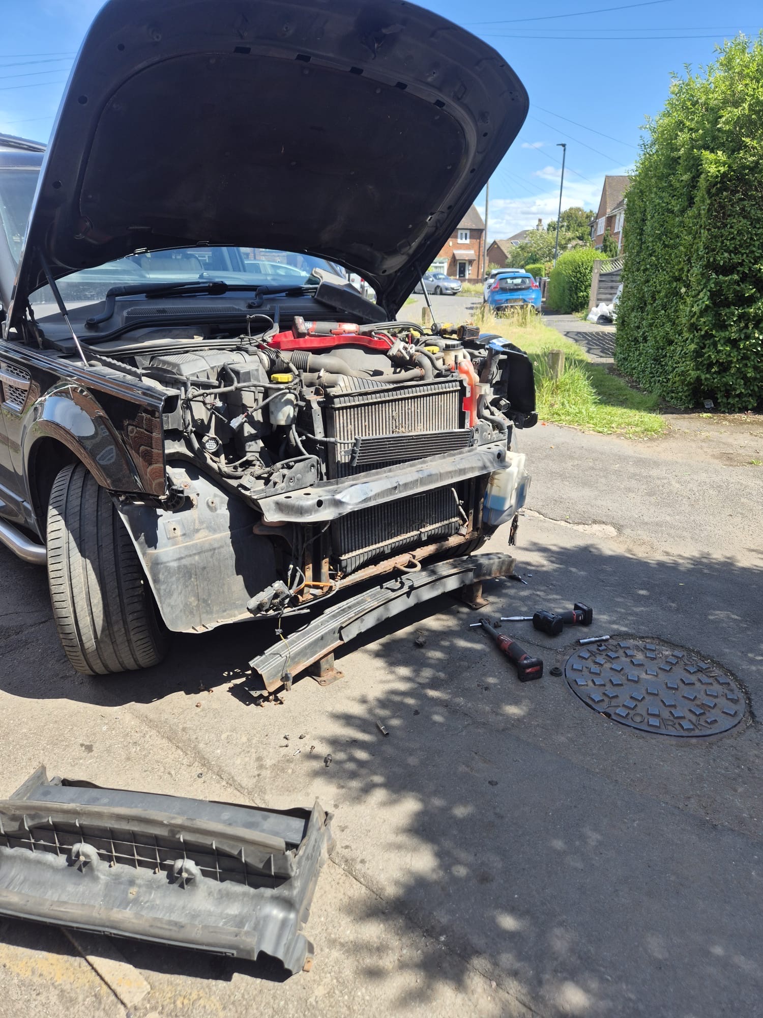 Front end of a Land Rover Discovery stripped down to access the air conditioning condenser